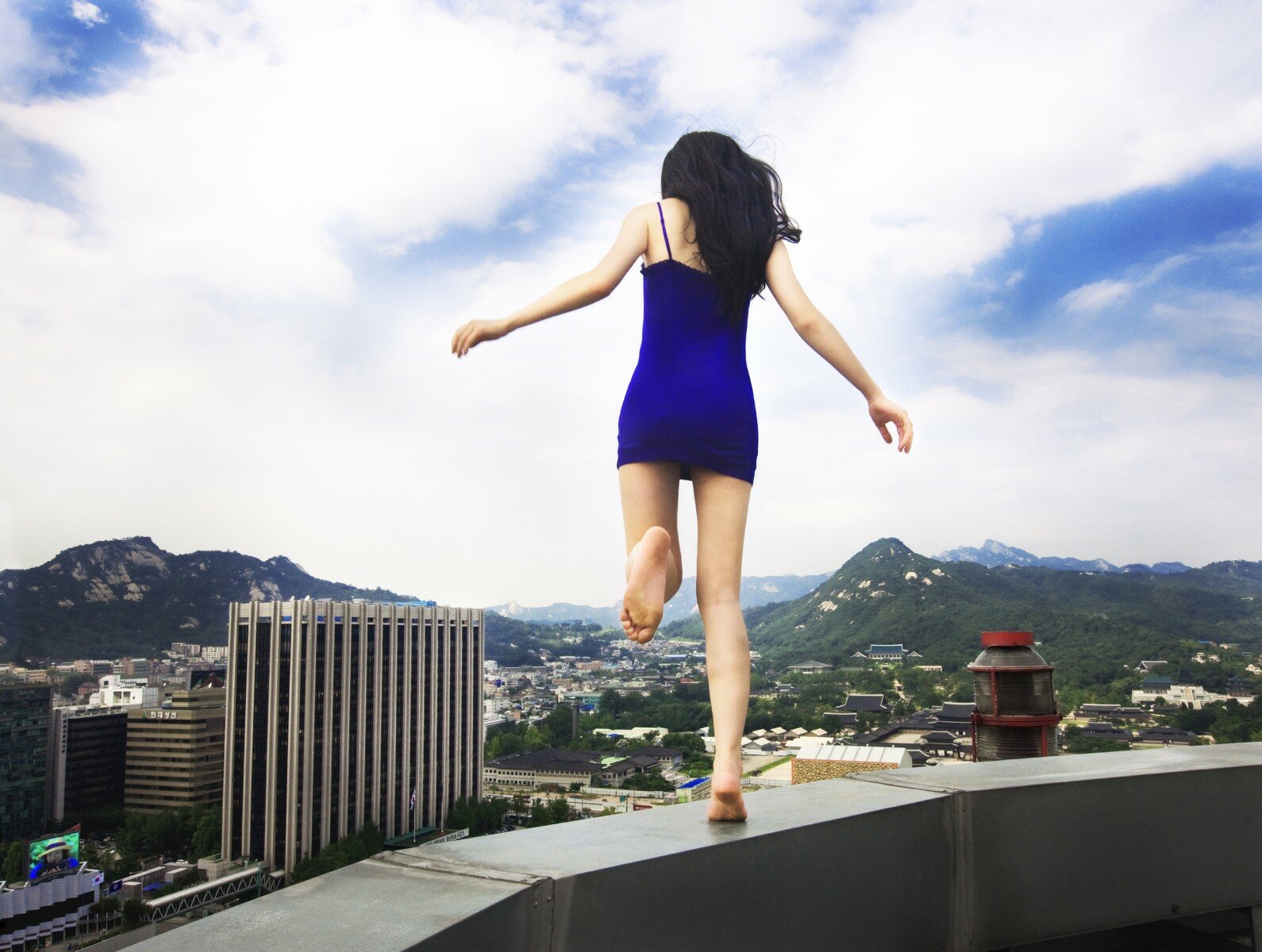 Обнаженная худая девушка взобралась на крышу многоэтажки